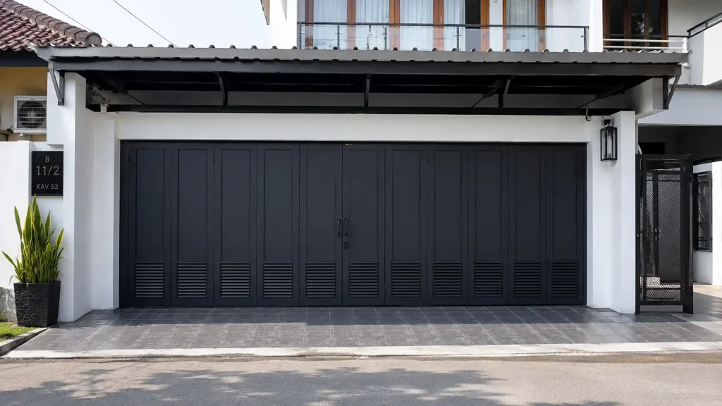 Pintu lipat besi minimalis pada garasi rumah modern dengan fasad rapi dan pencahayaan natural.